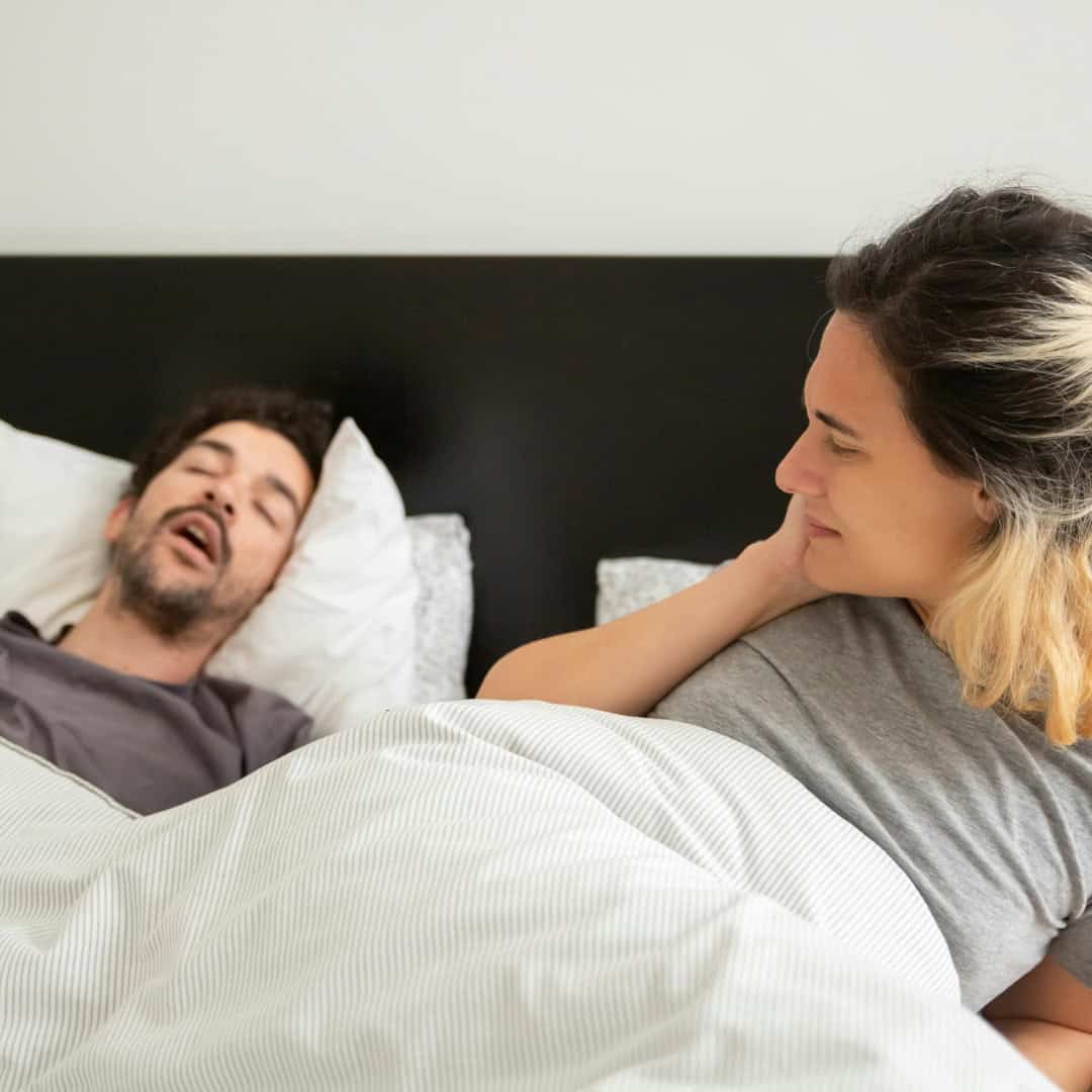 Feleség riadtan néz alvási apnoe-val küzdő férjére